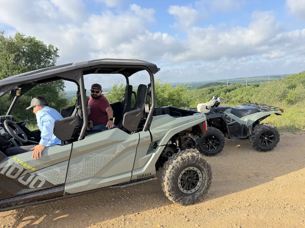 Yamaha RMAX4 UTV and Kodiak 450 ATV together on a scenic Texas trail with riders